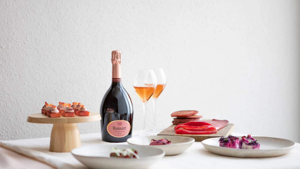 Ruinart Rosé champagne og elegante kanapeer på en hvid dug