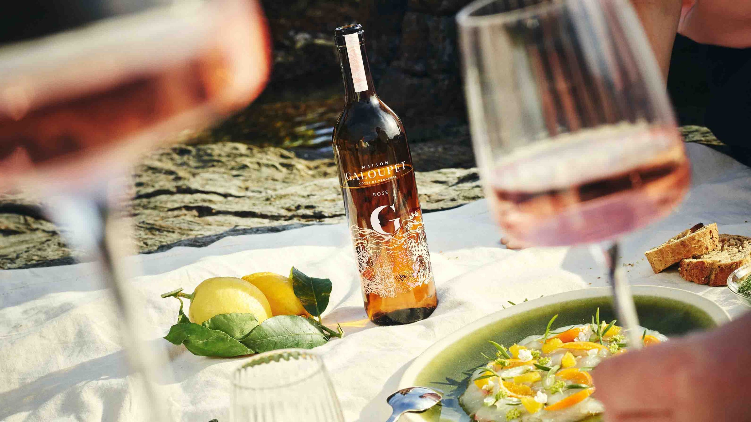 G de Galoupet rosévin, to glas og mad på hvidt tæppe