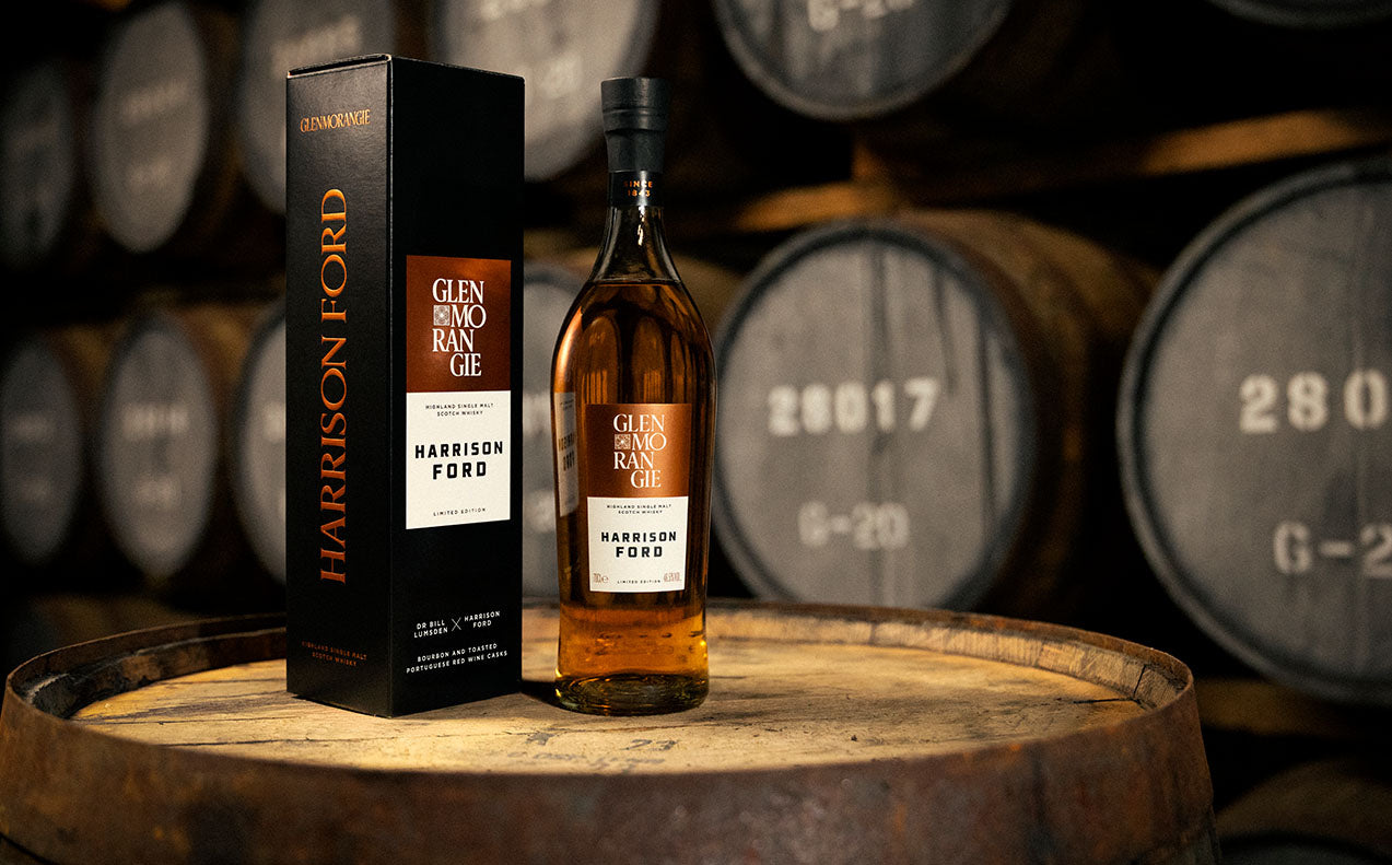 En flaske Glenmorangie x Harrsion Ford Whisky placeret på en tønde i et whisky lager