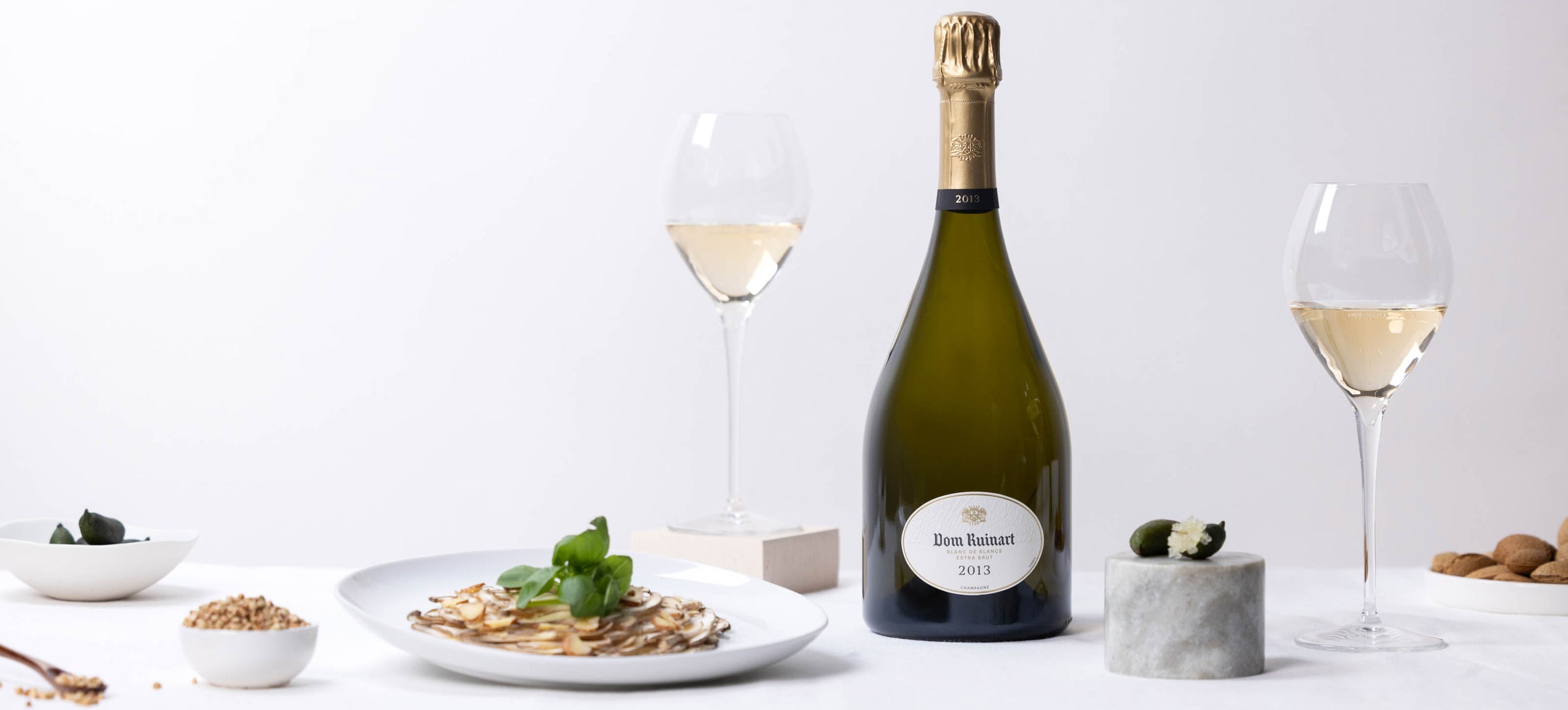 Dom Ruinart Blanc de Blancs 2013 champagneflaske og glas med madpar.