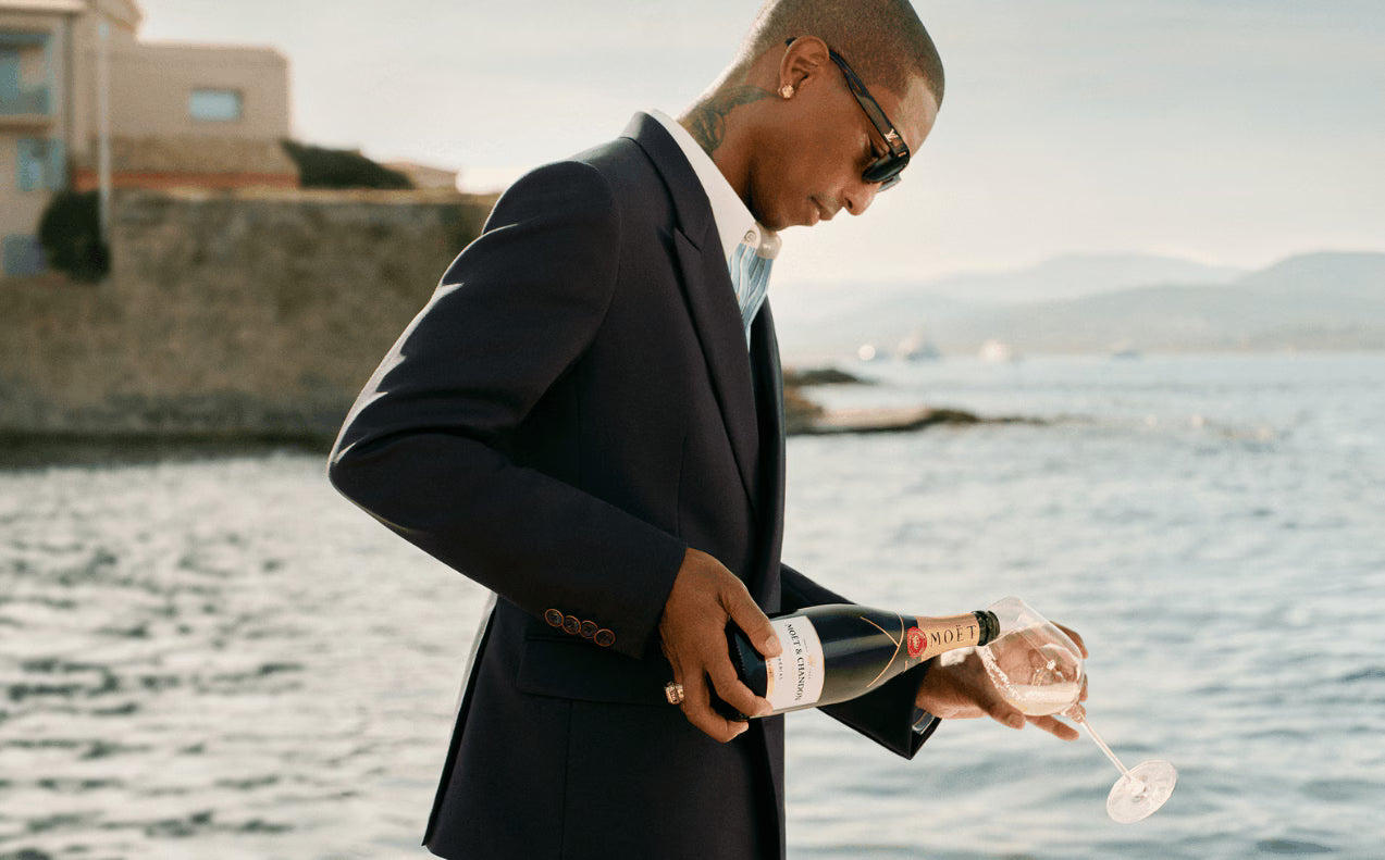 Pharrell Williams hælder en flaske Moet brut op i et glas