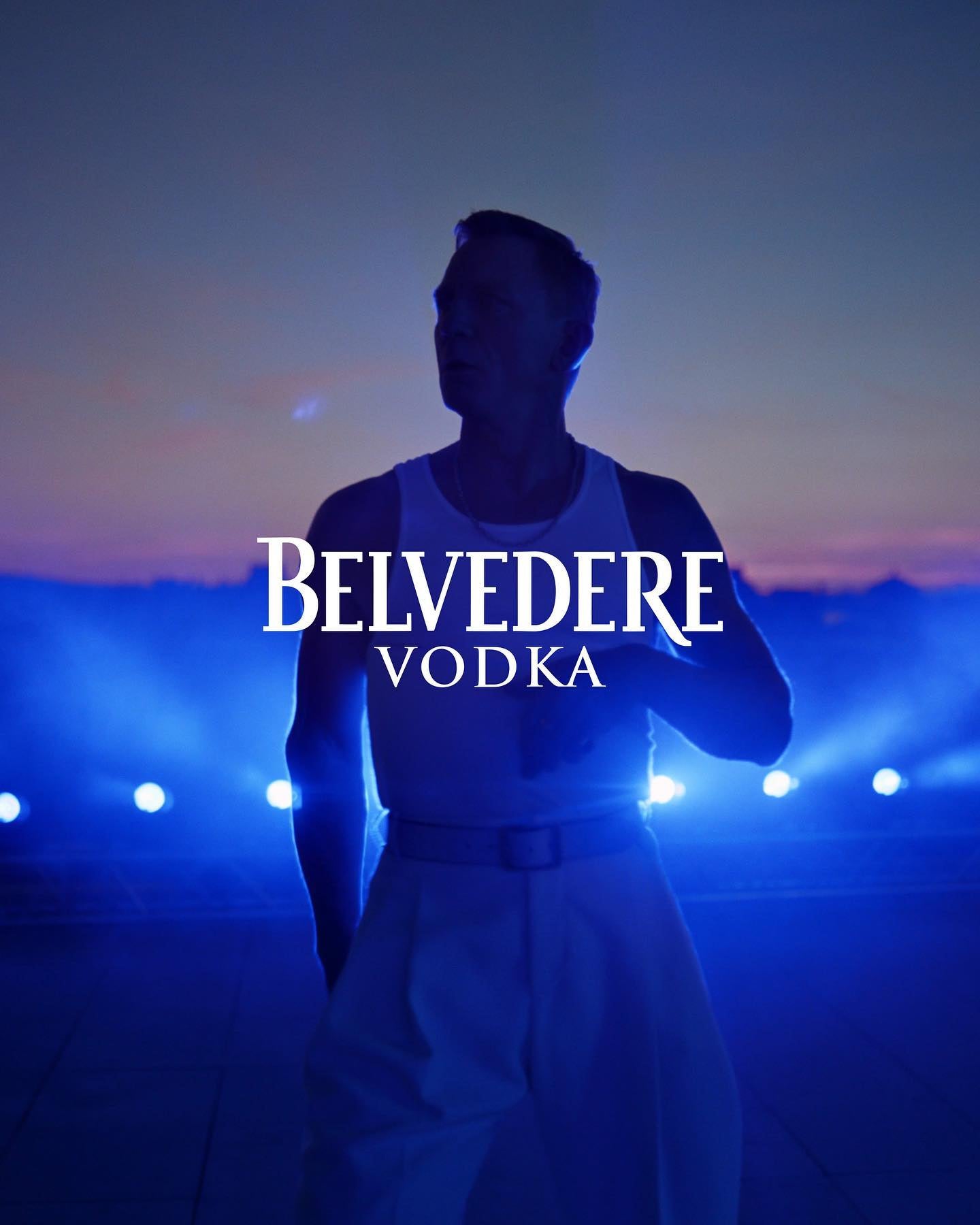 Mand silhuet danser i mørke med Belvedere Vodka logo.