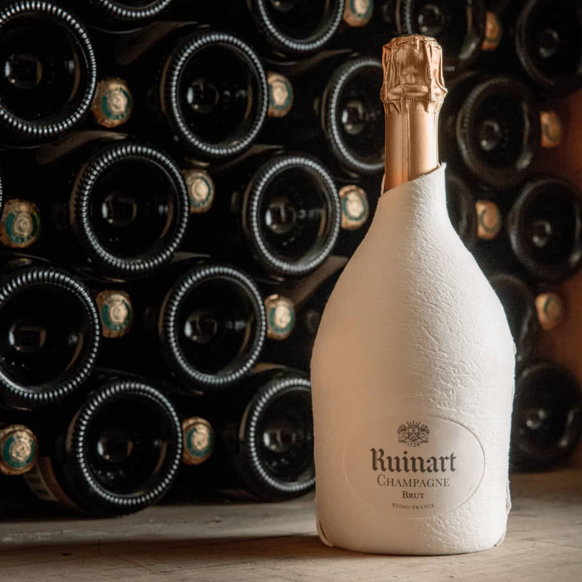 Ruinart flaske i miljøvenlig pakke af hvide fibre blandt andre champagneflasker