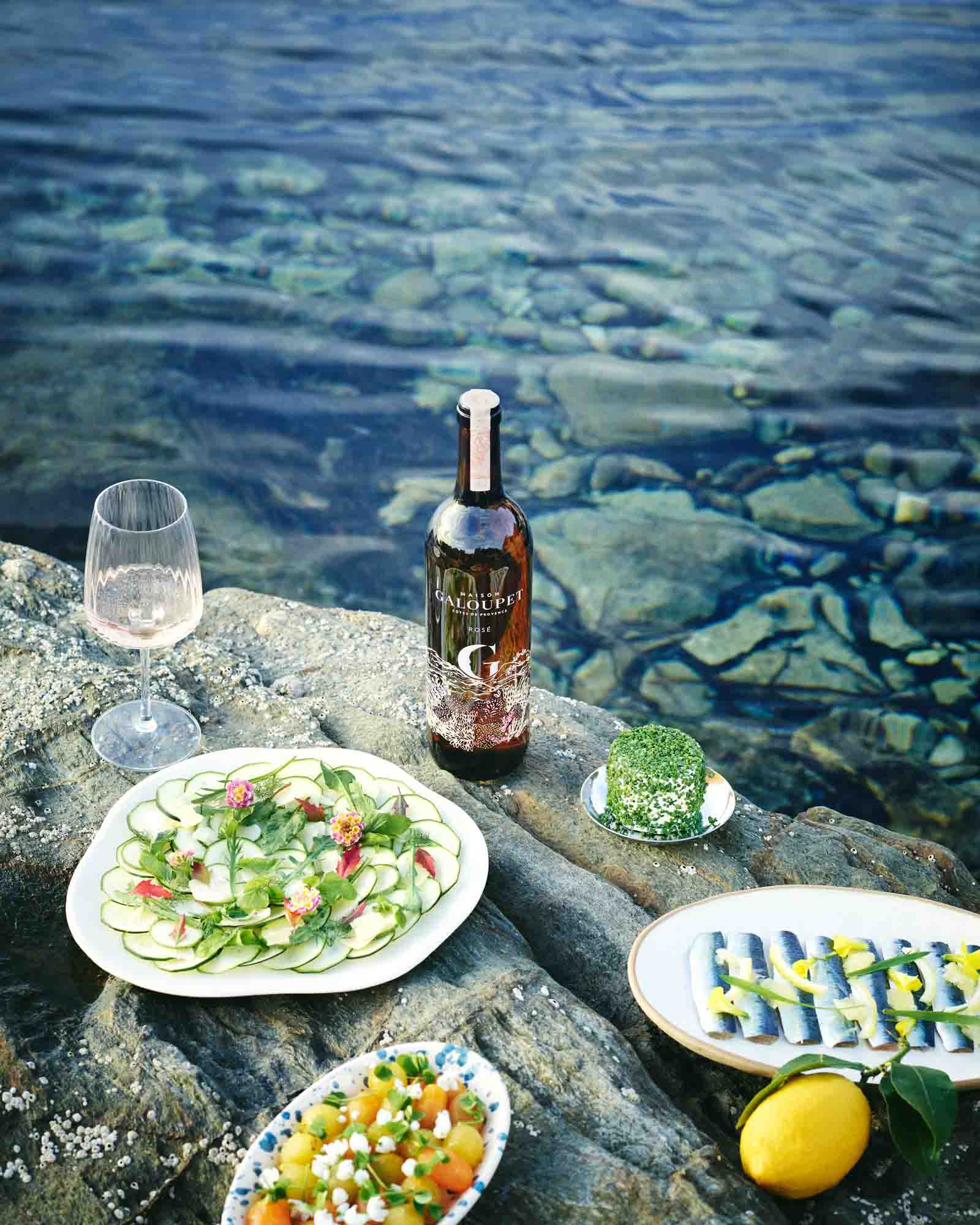 Billede af G de Galoupet rosévin, glas, salat, sild på klipper ved vandet