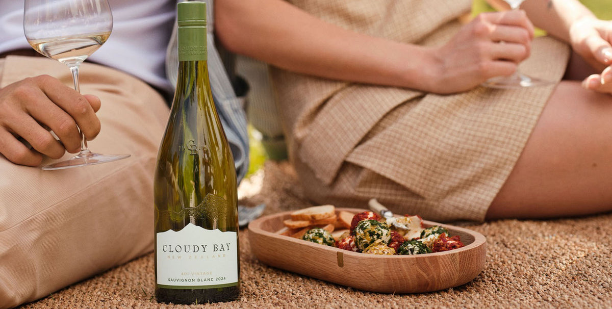 En flaske Cloudy Bay Sauvignon Blanc med på picknick med en let tapas ret ved siden af