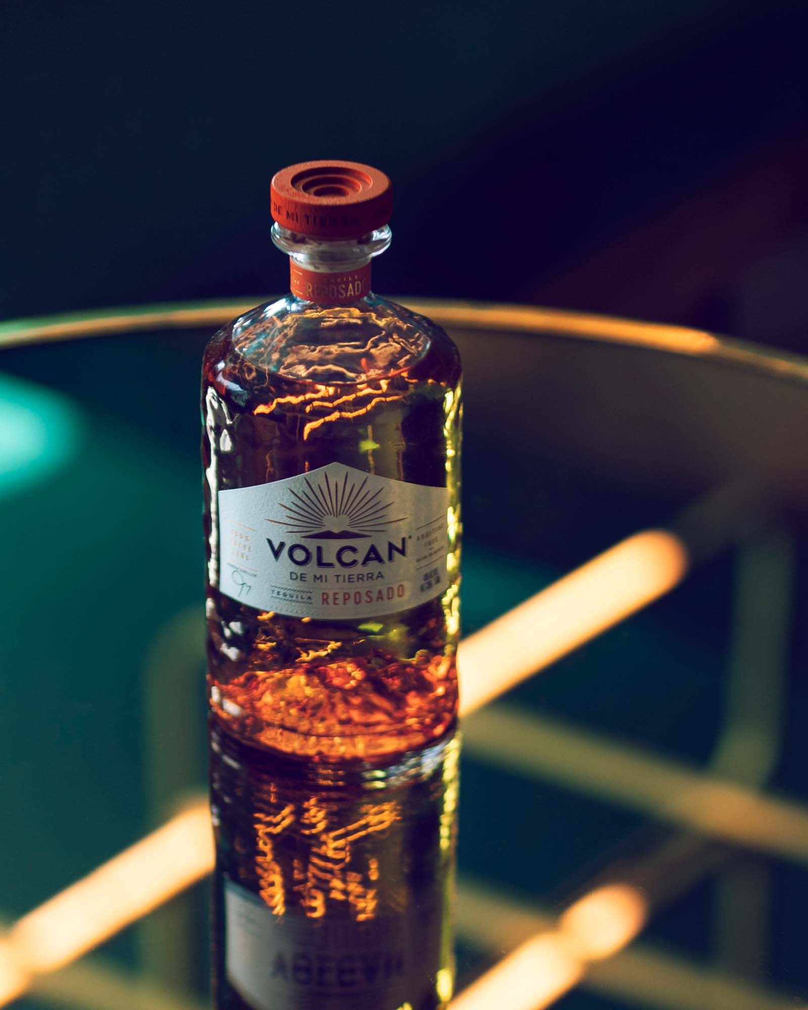 Volcan De Mi Tierra Reposado tequila flaske på et reflekterende bord