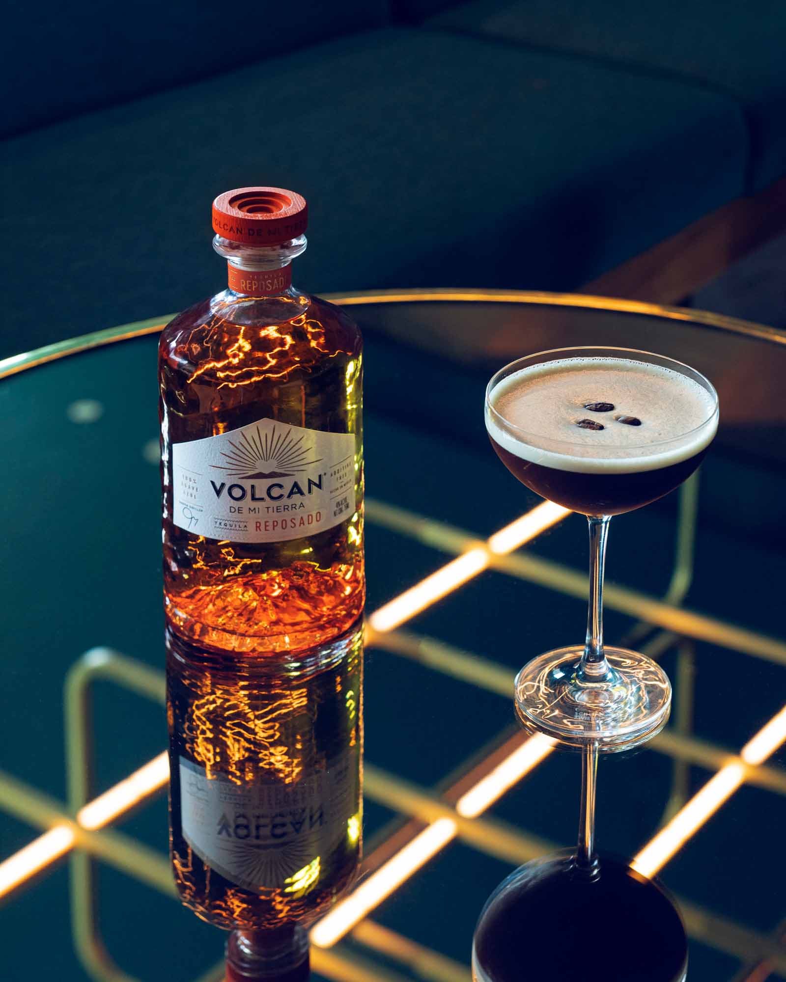 Volcan De Mi Tierra Reposado tequilaflaske og cocktail på et bord