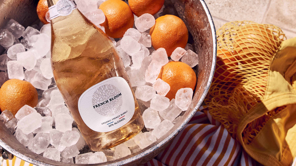 En stor magnum french bloom alkoholfri flaske i en bowle fyldt med isterninger.