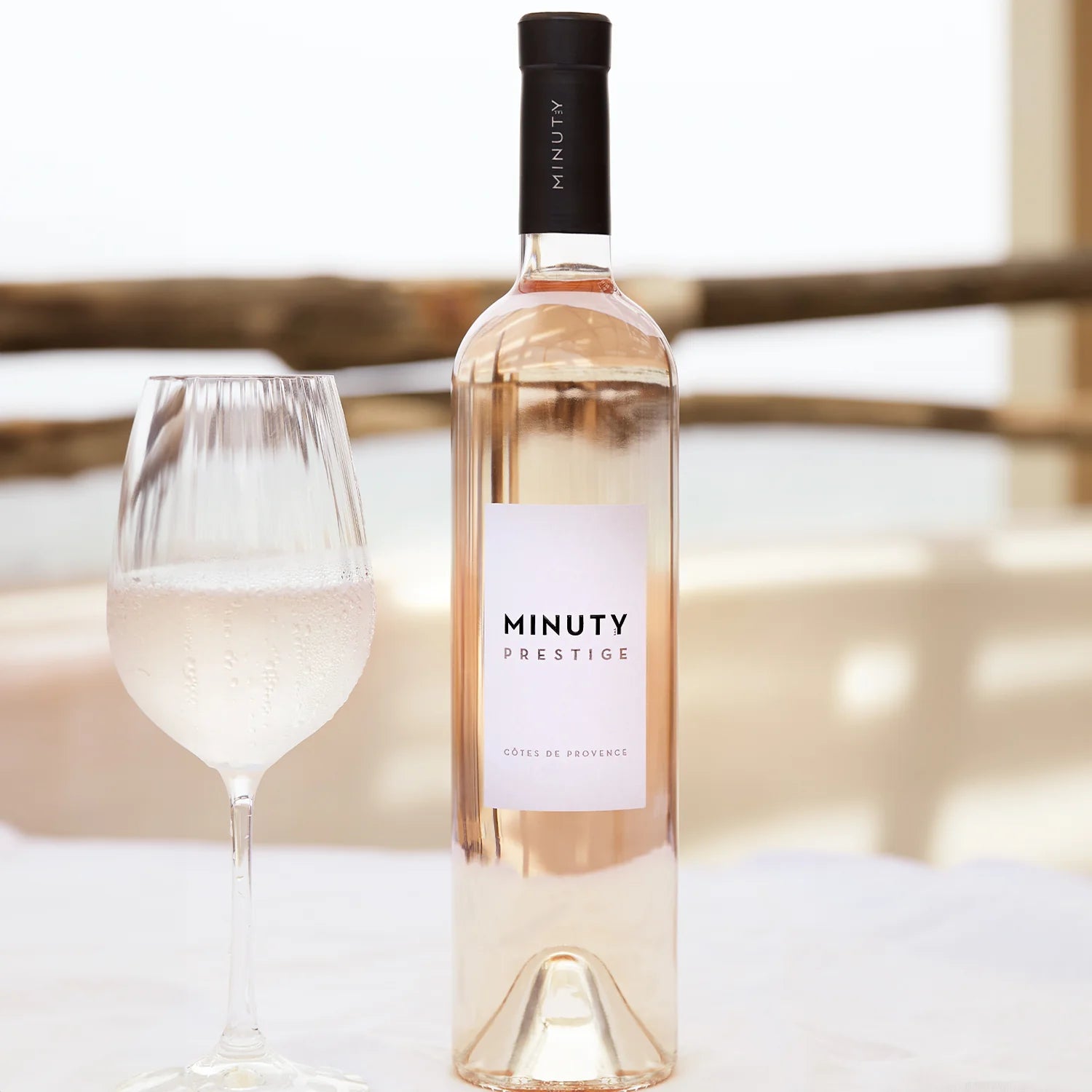 Minuty Prestige rosévin og et glas med vin på et bord