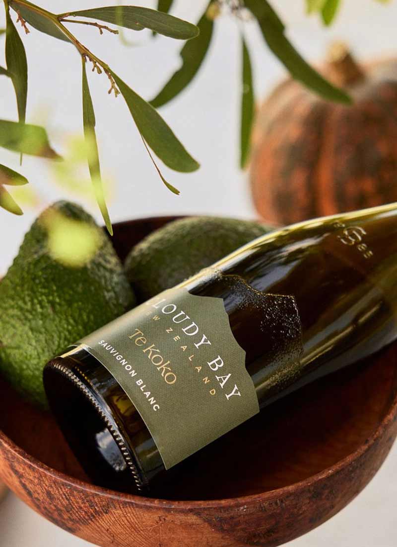 Cloudy Bay Te Koko Sauvignon Blanc vinflaske med avocadoer i træskål