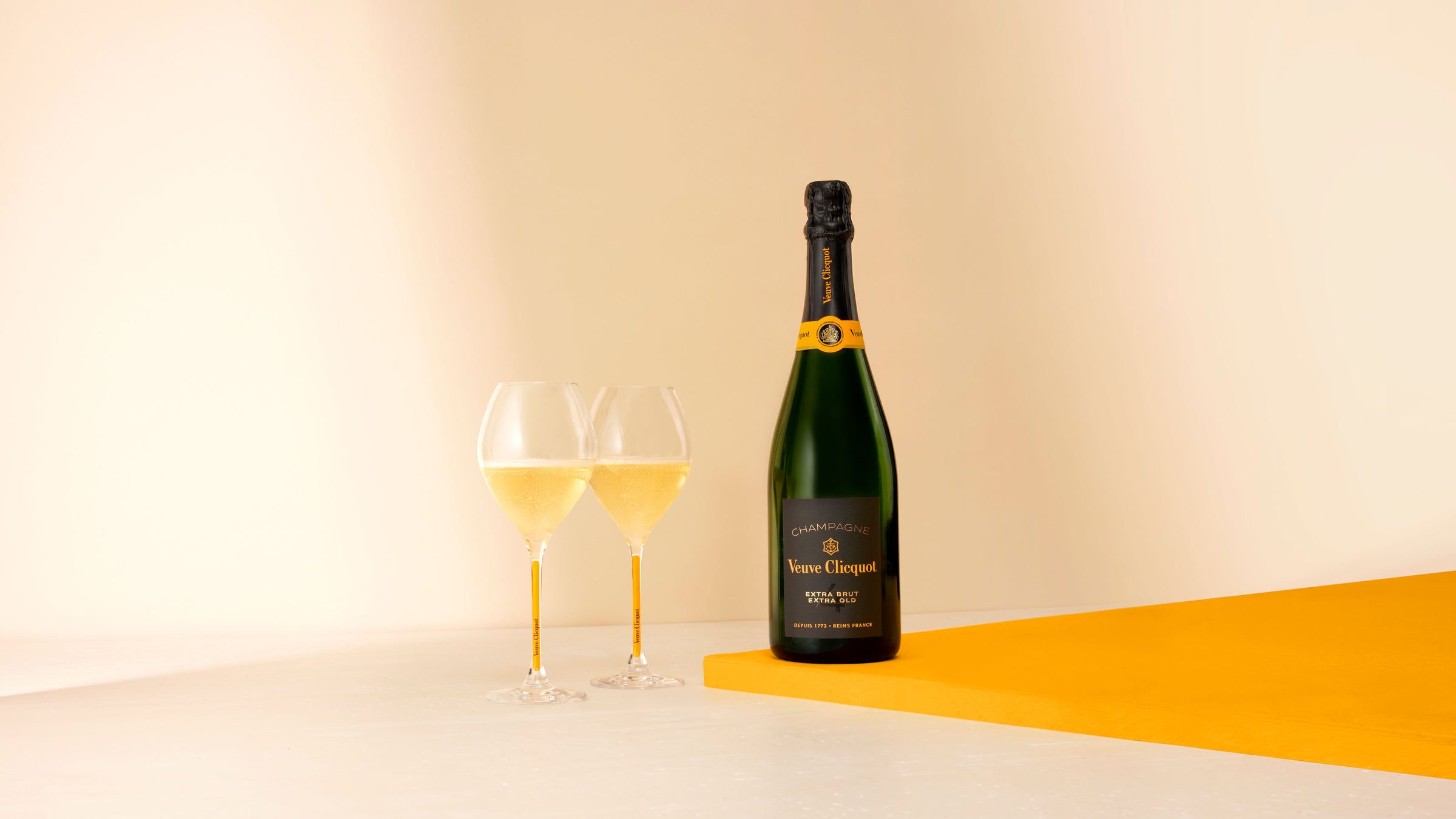 Veuve Clicquot Extra Brut Extra Old champagneflaske og to fyldte champagneglas