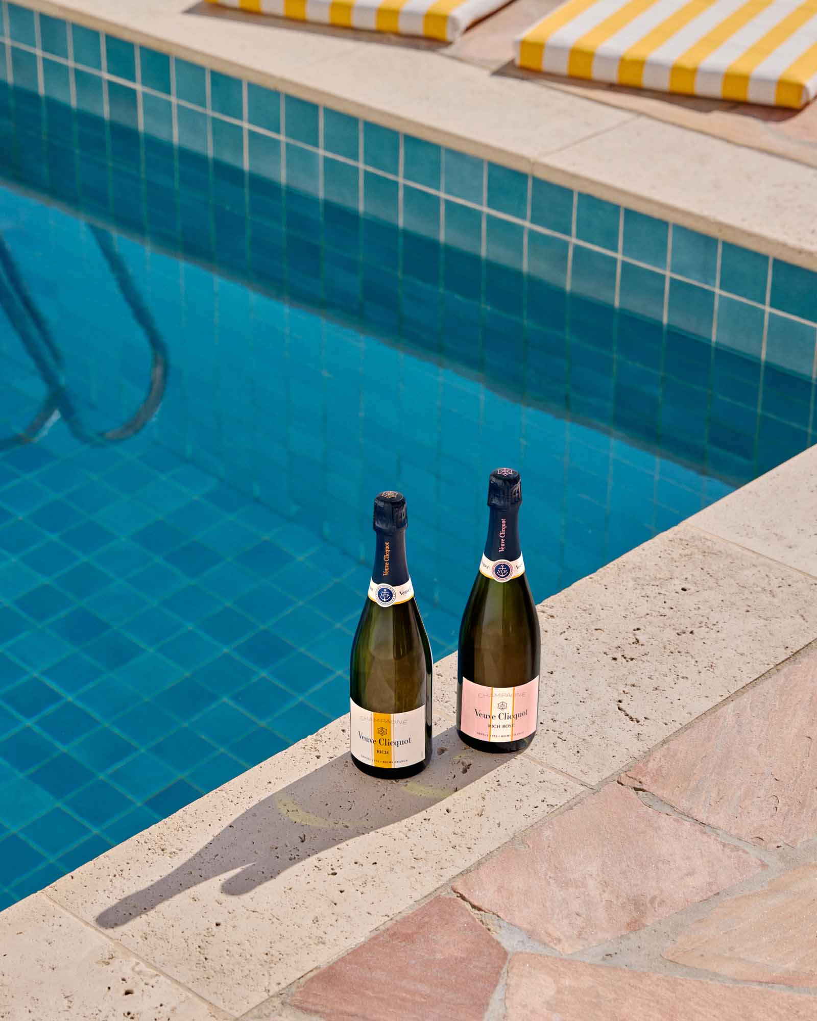 To flasker Veuve Clicquot RICH mousserende vin ved swimmingpool kanten.