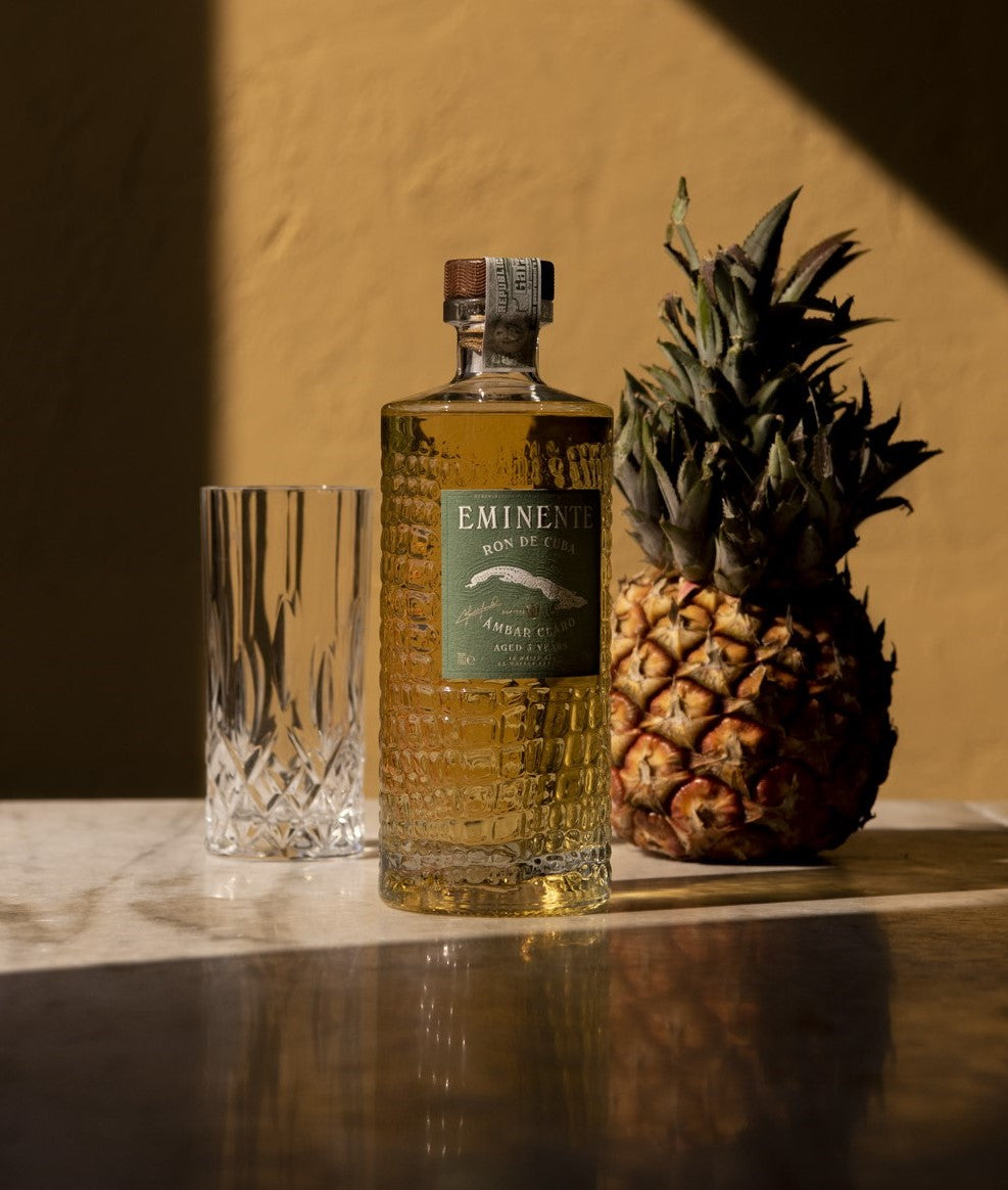 Eminente Ambar Claro 3 års rom, ananas og glas på bord